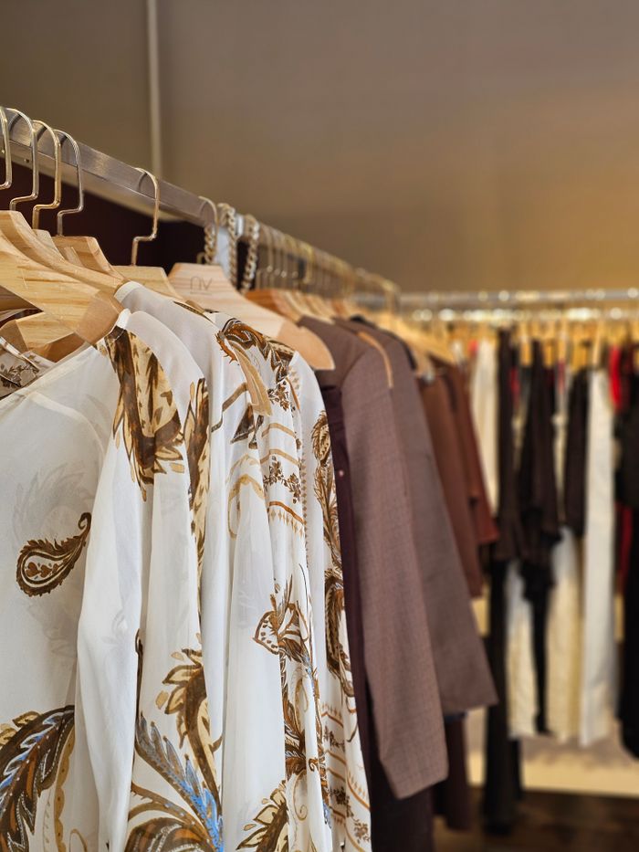 Stylish assortment of clothes hanging on racks in a fashionable boutique featuring elegant patterns.